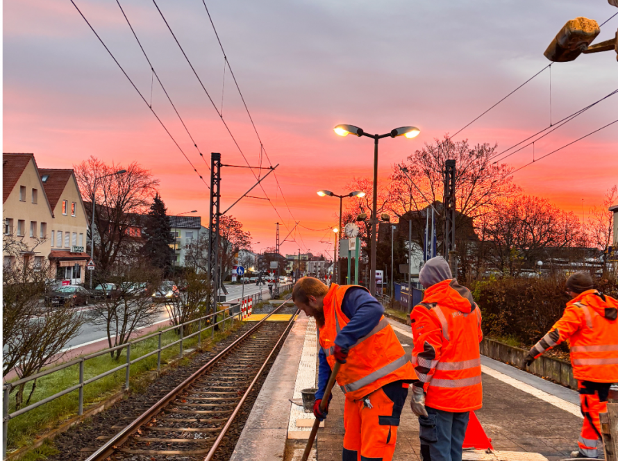 Mitarbeiter erneuern Bodenbelag am Bahnsteig